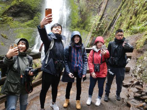 Five hikers take selfies at the upper platfrom at Marymere Falls which flows into Barnes Creek which flows into Lake Crescent