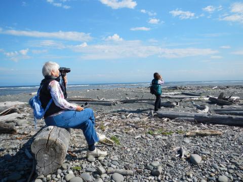 Two birders looking through binoculars at the mouth of the Elwha River