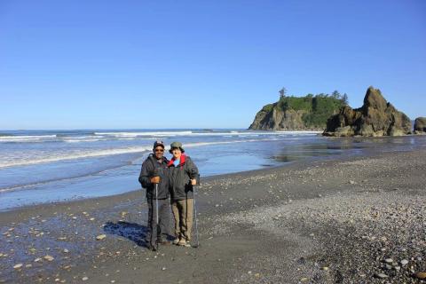 Two participants posing on an Olympic National Park Beach with rocky islands in the distance