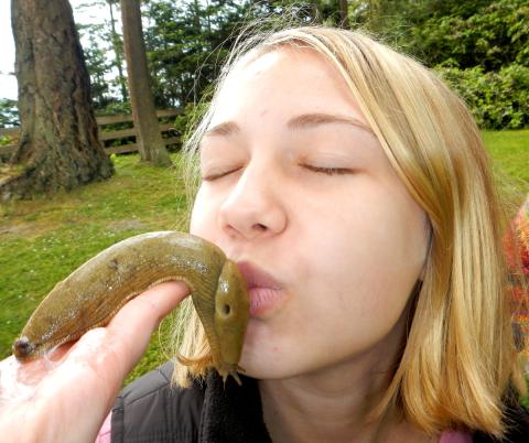 A young tour participant "kisses" a large yellow Banana Slug